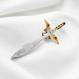 Decorative sword brooch with gold and silver design on a white background