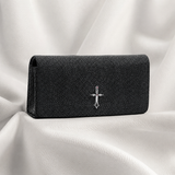 Black textured wallet with a silver emblem on a white fabric background