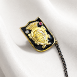 Decorative brooch with chain and gemstones on a white fabric background